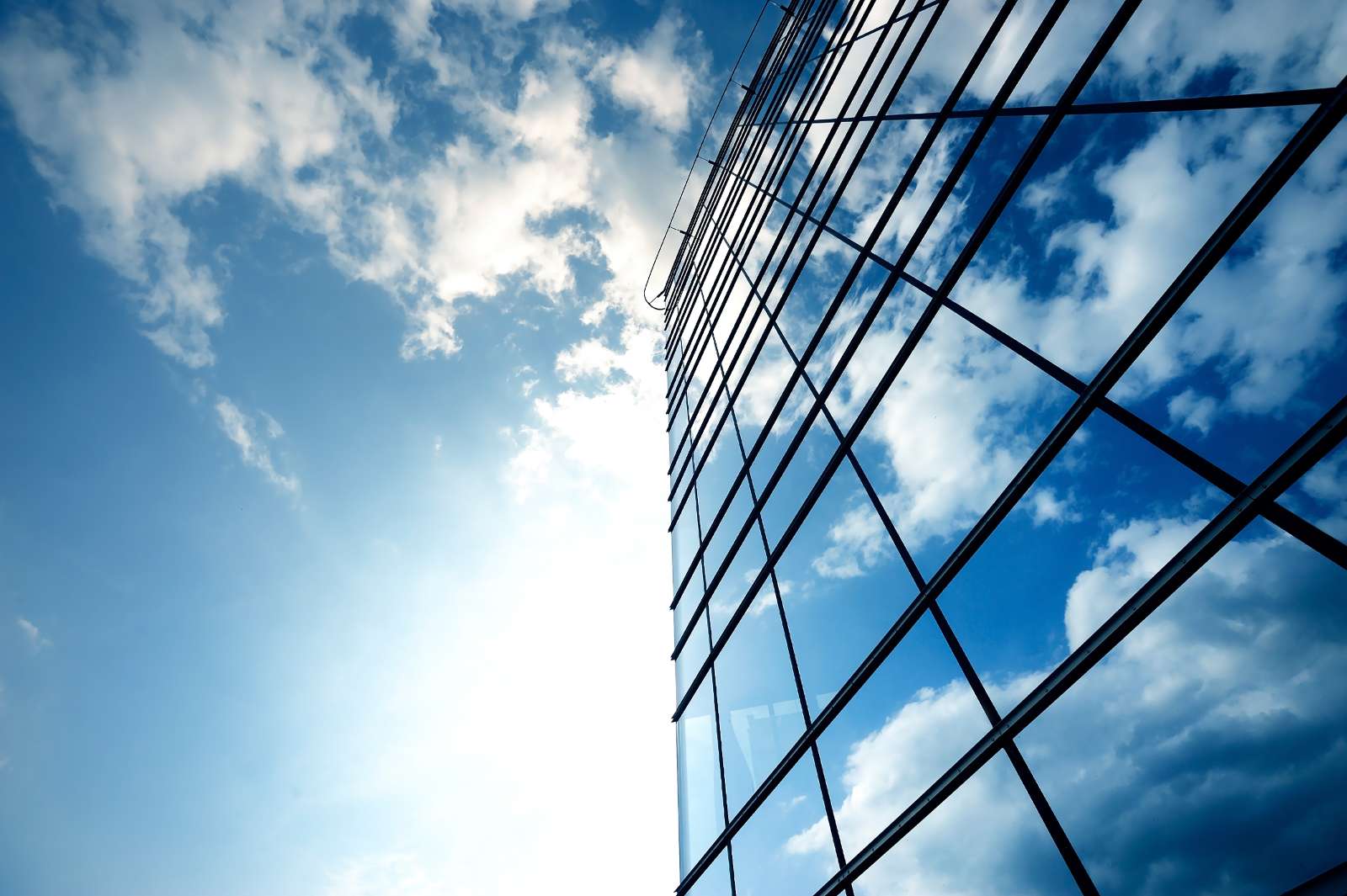 Modernes Gebäude reflektiert bewölkten Himmel mit Glasfassade